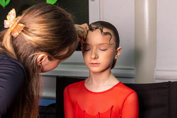 master creates professional makeup for a girl in ballroom dancing, junior class