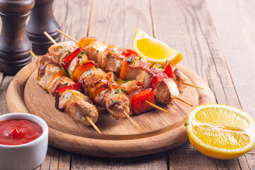 Delicious grilled chicken skewers with capsicum, lemon, salad and ketchup on a plate over the table. Chicken kebab. Healthy food concept.