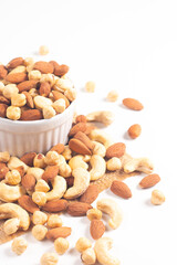 Large assortment of nuts in different bowls on stone table.