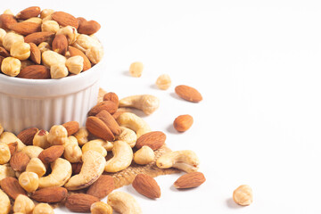 Large assortment of nuts in different bowls on stone table.