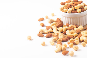 Large assortment of nuts in different bowls on stone table.