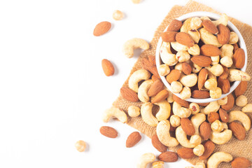 Large assortment of nuts in different bowls on stone table.