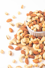 Large assortment of nuts in different bowls on stone table.