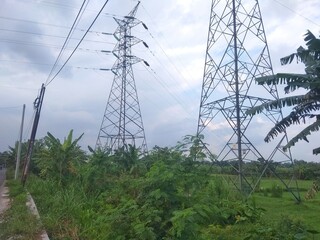 High voltage electricity cable poles in rice fields far from residential areas.