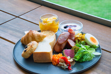 緑の美しい季節に、休暇で滞在したホテルの屋外のテラスでいただくラグジュアリーな朝食の風景
