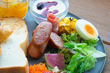 緑の美しい季節に、休暇で滞在したホテルの屋外のテラスでいただくラグジュアリーな朝食の風景