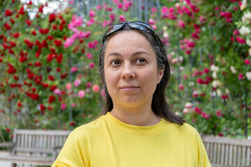 Portrait of a woman in a summer park among beautiful flowers.