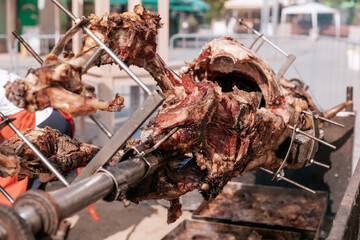 Close-up of roasted animal head on a spit, part of traditional Serbian open-fire meat preparation