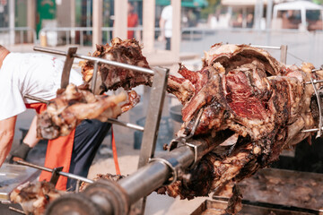 Roasting whole animal over large outdoor barbecue at a traditional food festival