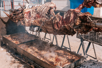 Roasting whole animal over large outdoor barbecue at a traditional food festival