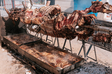 Roasting whole animal over large outdoor barbecue at a traditional food festival