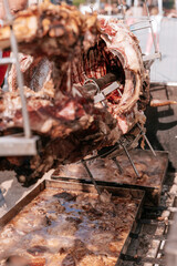 Close-up of roasted animal head on a spit, part of traditional Serbian open-fire meat preparation