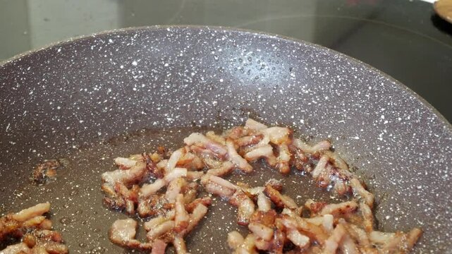 Crispy bacon sizzling in a pan, showing the golden-brown texture and crisp edges