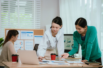 Fototapeta premium Diverse business team in modern office collaborating on startup strategy, analyzing charts, discussing growth, and planning successful marketing project.