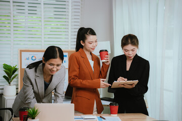 Asian business team collaborating in office, discussing strategy and project planning; professional...