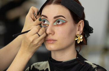 Makeup artist doing professional makeup in visage studio.