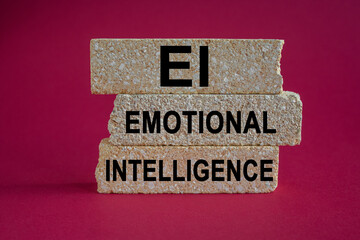 Concept words 'EI emotional intelligence' on brick blocks. Beautiful pink background. Business...