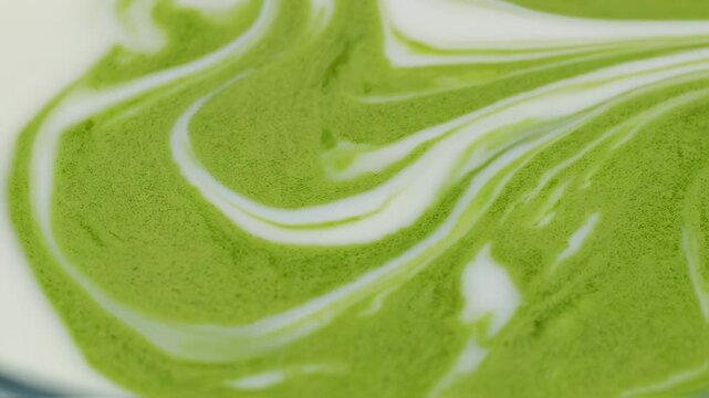gentle swirl of vibrant matcha green dissolving into creamy white, creating soft waves and a calming, organic texture