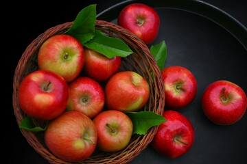 apples in a basket, black background. Red ripe small apples after harvest 