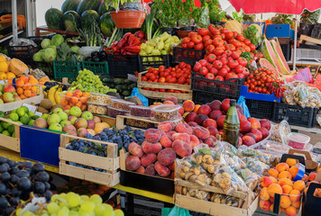 A vibrant outdoor market stand displays a colorful assortment of fresh fruits in wooden crates, showcasing natures seasonal bounty.