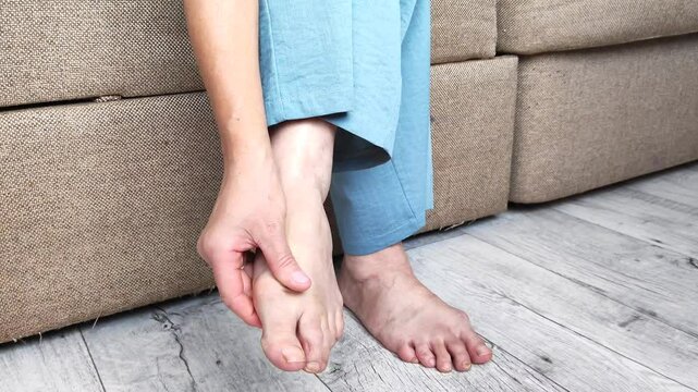 A woman suffering from arthritis or arthrosis of the legs puts special attachments on her legs to reduce pain and discomfort