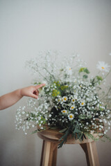 白いフラワーアレンジと子どもの手