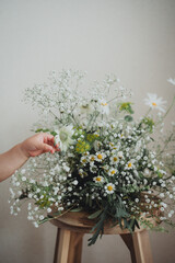 白いフラワーアレンジと子どもの手