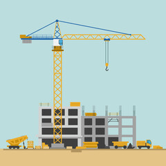 A construction crane towering over a building site with materials and workers nearby