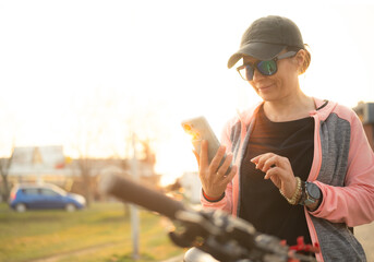 Woman Checking Bike Route On A Smartphone With Gps Map on city street