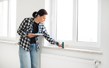 Girl Uses A Laser Measure To Check Window Dimensions For Room Renovation