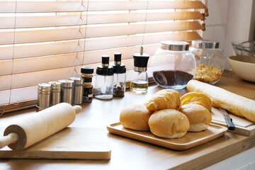 The croissant bread is placed on a wooden tray in the kitchen.