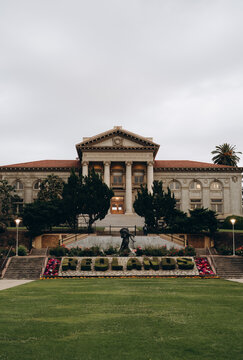 The exterior of the University of Redlands, with a green alley on the way to it and bushes in the shape of the university's name planted in front of it.