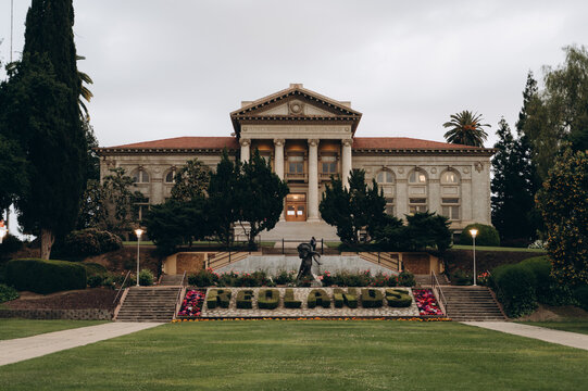 Redlands University in spring, everything is green, cherry blossoms are blooming on the alley leading to the university entrance.