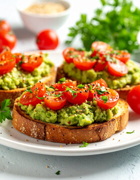 Toasted bread with mashed avocado, sliced cherry tomatoes. Tasty snack.