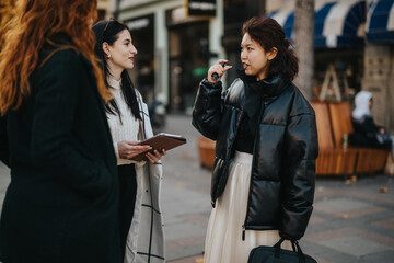 Three women are engaging in a friendly conversation on a city street, expressing connection and camaraderie. They are dressed warmly, illustrating a lively and sociable outdoor environment.