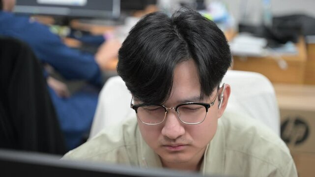 Young Software Developer Sitting at a Modern Office Desk, Deeply Focused on Writing Code on a Dual-Monitor Setup in a Bright, Minimalist Workspace with Contemporary Tech Equipment and Coffee Mug