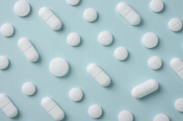 Flat Lay of White Pills on Light Blue Background, Clinical and Minimalist Medicine Concept