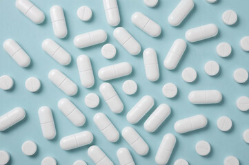 Flat Lay of White Pills on Light Blue Background, Clinical and Minimalist Medicine Concept