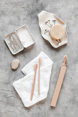 Zero-waste bathroom essentials: natural bristle brushes, bamboo toothbrushes, and tooth powder in tin. Plastic-free flat lay of sustainable hygiene items on soft neutral background