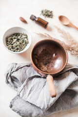 Natural self-care flat lay with a copper vessel, herbs, essential oil, and wooden tools. Herbal rituals, sustainable wellness, and plant-based remedies in earthy, apothecary style