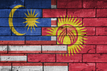 colourful painted big national flag of malaysia and flag of kyrgyzstan on a massive old brick wall background. concept