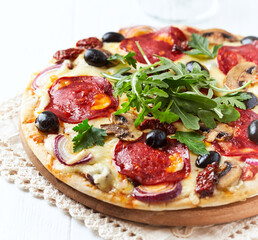 Pizza with chorizo ​​sausage, mozzarella and olives. Wooden background. Close up.	