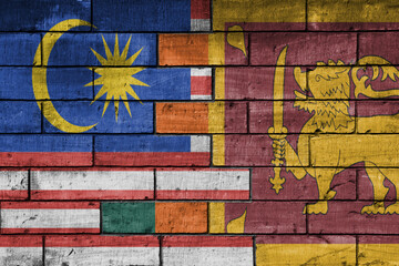 colourful painted big national flag of malaysia and flag of sri lanka on a massive old brick wall background. concept