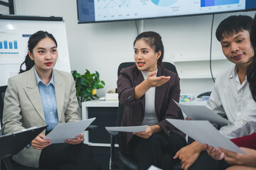 Asian businesspeople engaging in lively discussions and sharing innovative ideas during a collaborative meeting in a modern office setting