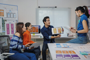 Team of Asian user experience designers working together developing new mobile application...