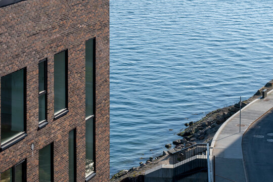 Urban building elevation with sharp window reflections and symmetry, Copenhagen, captured at eye level with clear lighting for clean modern background applications.