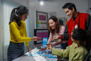Young creative team of asian ui and ux designers working together developing mobile app design in their office