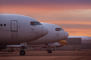 Obraz premium Large commercial aircraft are prominently featured, both parked side by side captures a moment of stillness characterized by motion, highlighting engineering elegance of modern aviation.