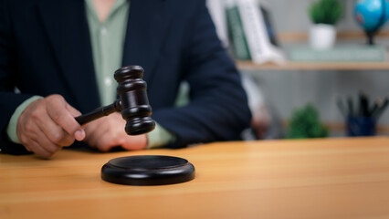 Hand holding gavel poised above base. Symbolizes justice, legal authority, and decisive action in court, law, or auctions. Ideal for representing judgment, powerful decisions, dispute resolution now.