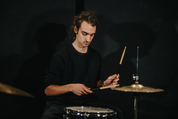A musician deeply engaged in practicing drumming during a rehearsal session for a gig. The scene conveys passion, focus, and the art of music as seen in a professional setting.